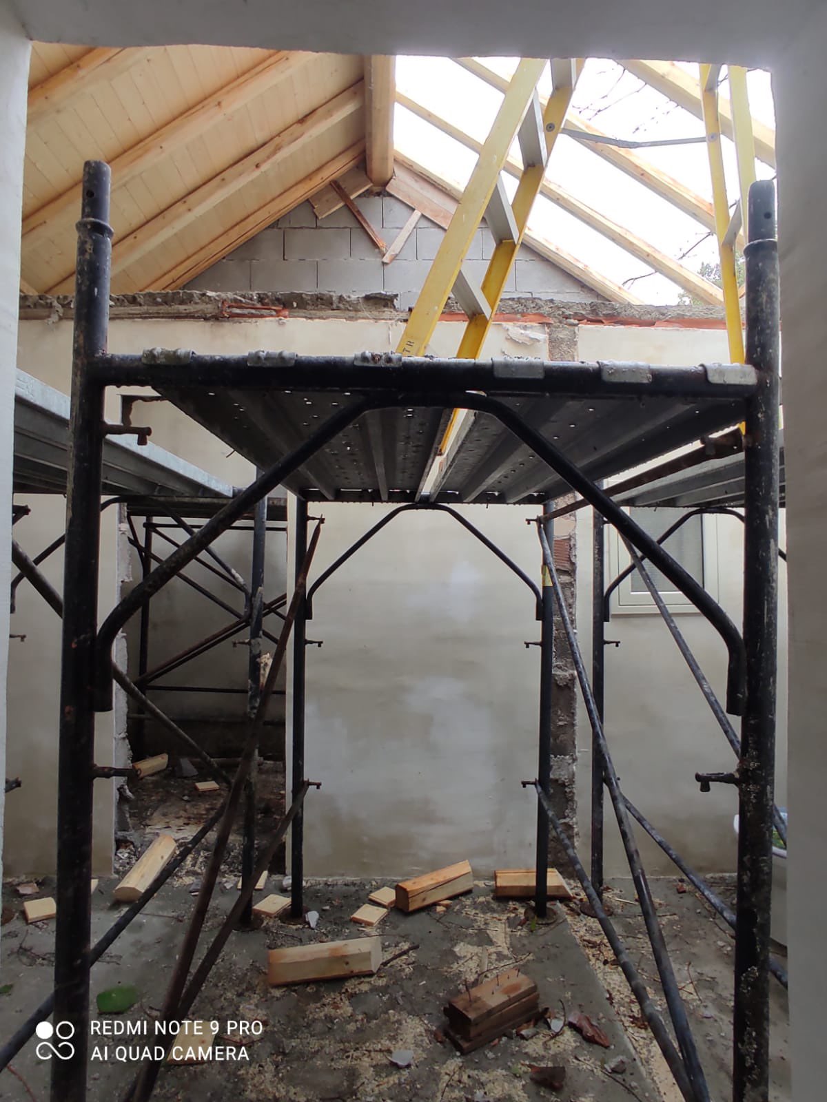 Scaffolding beneath the freshly built timber roof, opening the space to the light